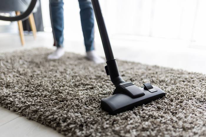 Vacuuming a carpet during a regular home cleaning visit in Dubai